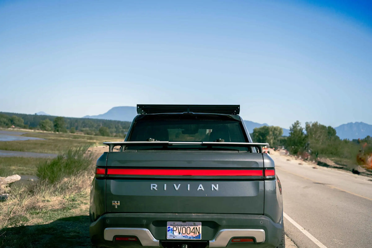 Vue arrière avec le logo Rivian et les montagnes en fond