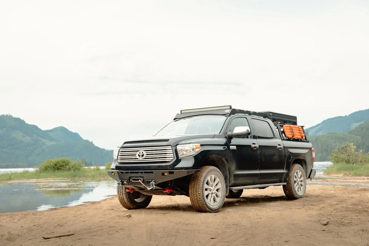 Vue éloignée du toyota tundra avec rack de toit VAN44 et bumper modifié au bord d'un lac en colombie britannique