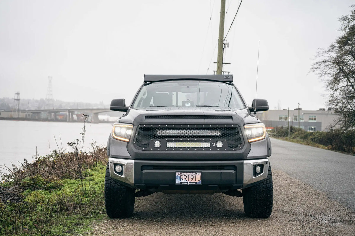 Vue de face du Toyota Tundra avec la mer à gauche et la route à droite et un rack de toit sur le toit
